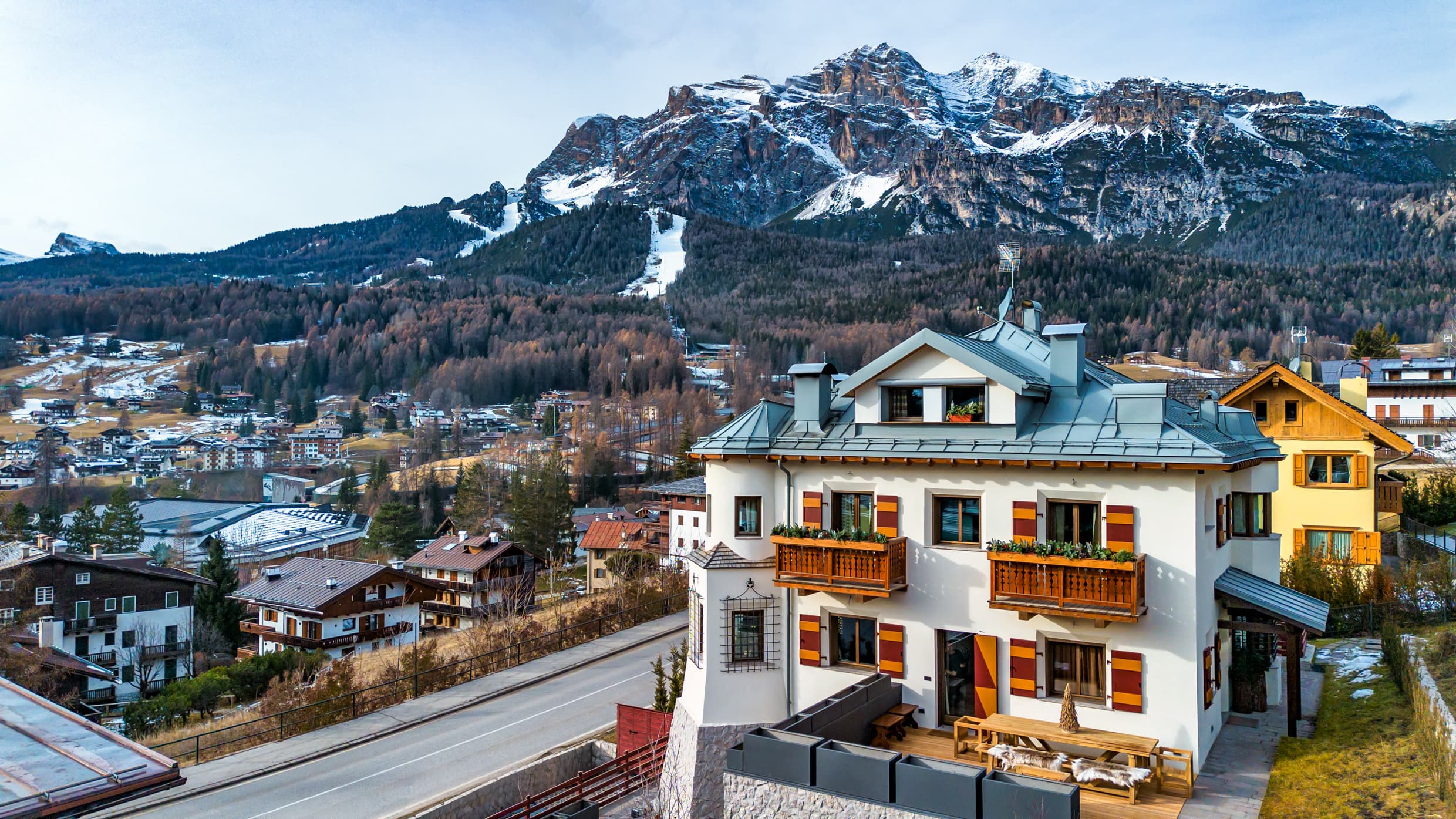 Vista aerea di Villa Il Castelletto, scuri tirolesi rossi e torretta con le Dolomiti innevate sullo sfondo — Cortina d'Ampezzo